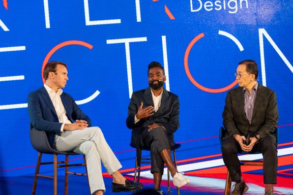 Rama on stage as part of a panel with two other people